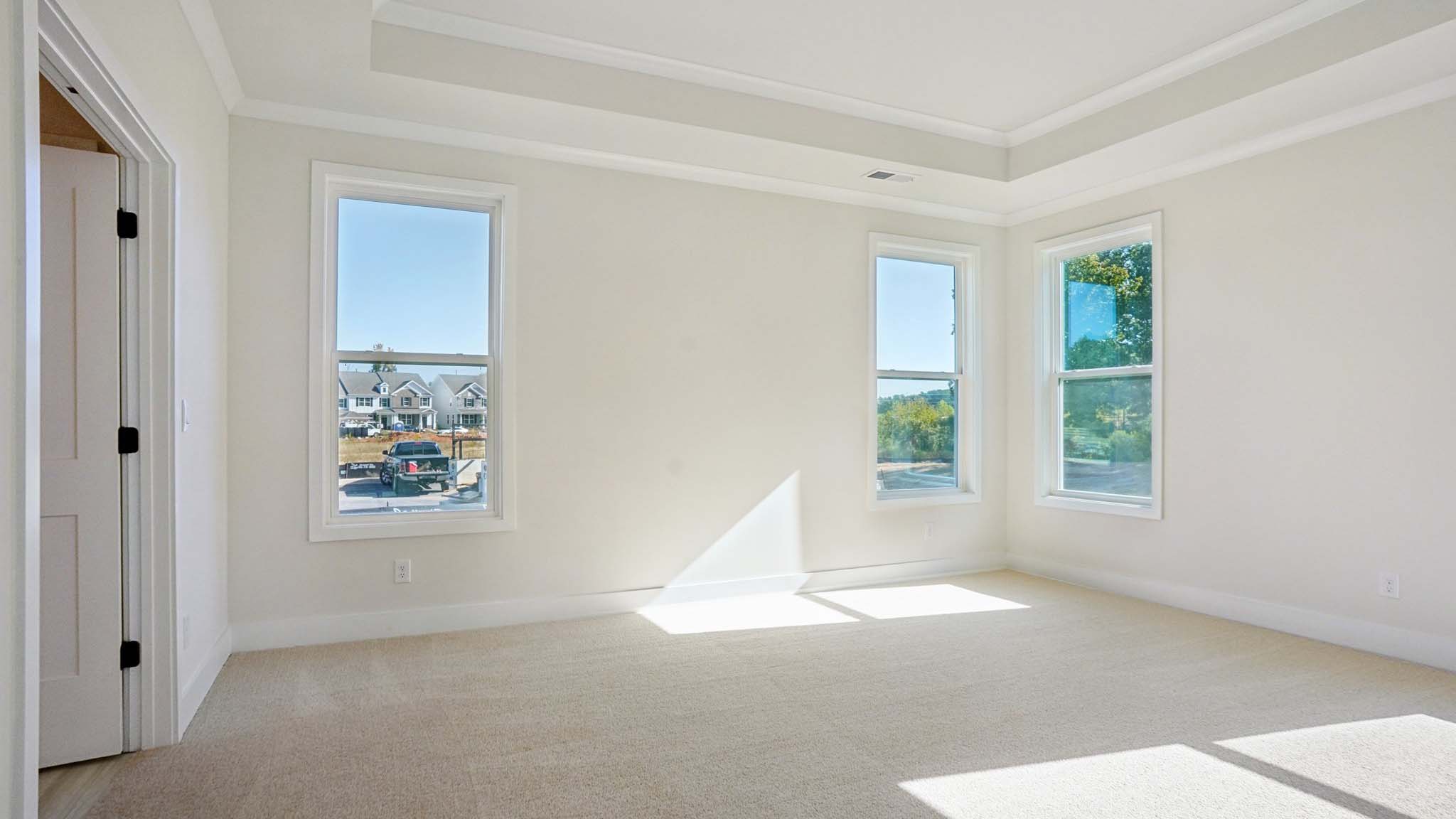 Carpeted primary bedroom with windows