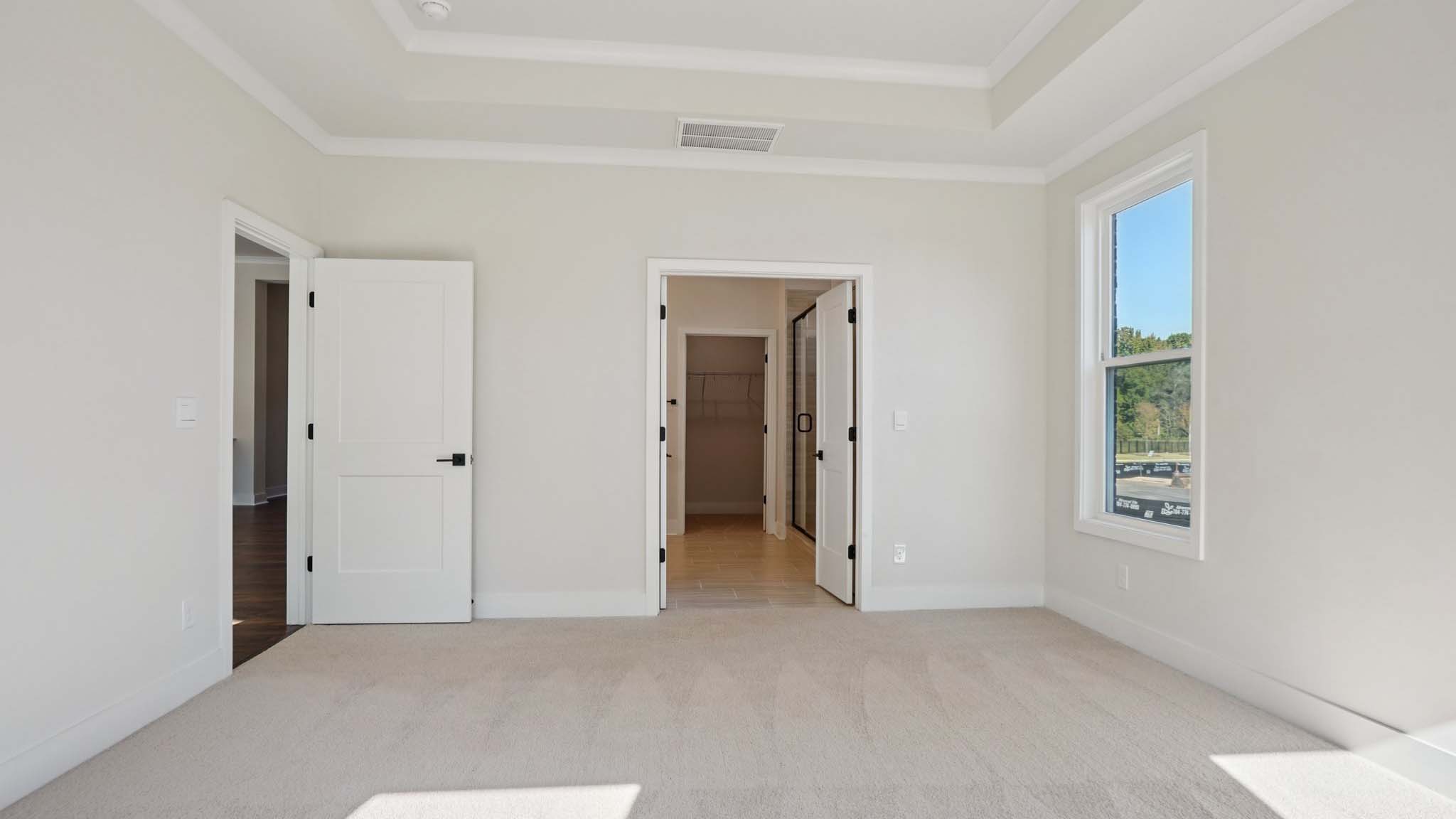 Carpeted primary bedroom with windows