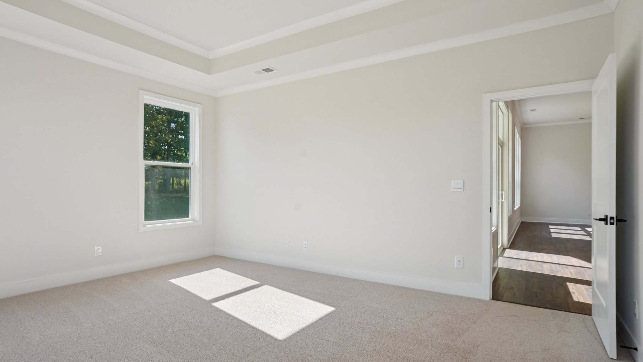 Carpeted primary bedroom with windows
