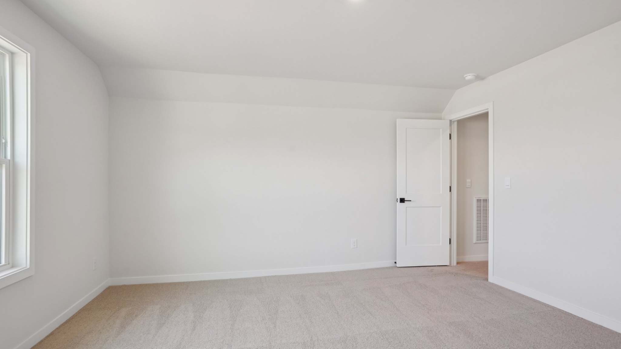 Carpeted bedroom with windows
