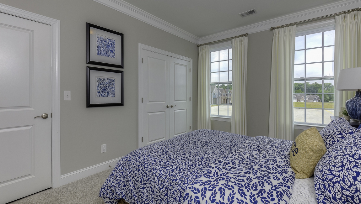 Carpeted bedroom with large windows