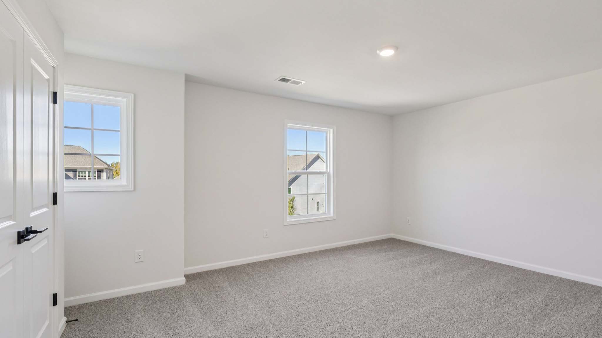 Carpeted bedroom with windows