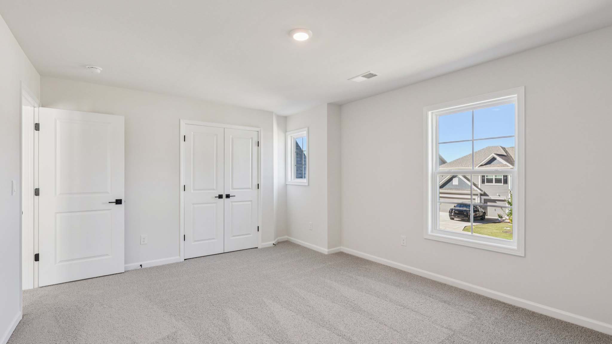 Carpeted bedroom with windows