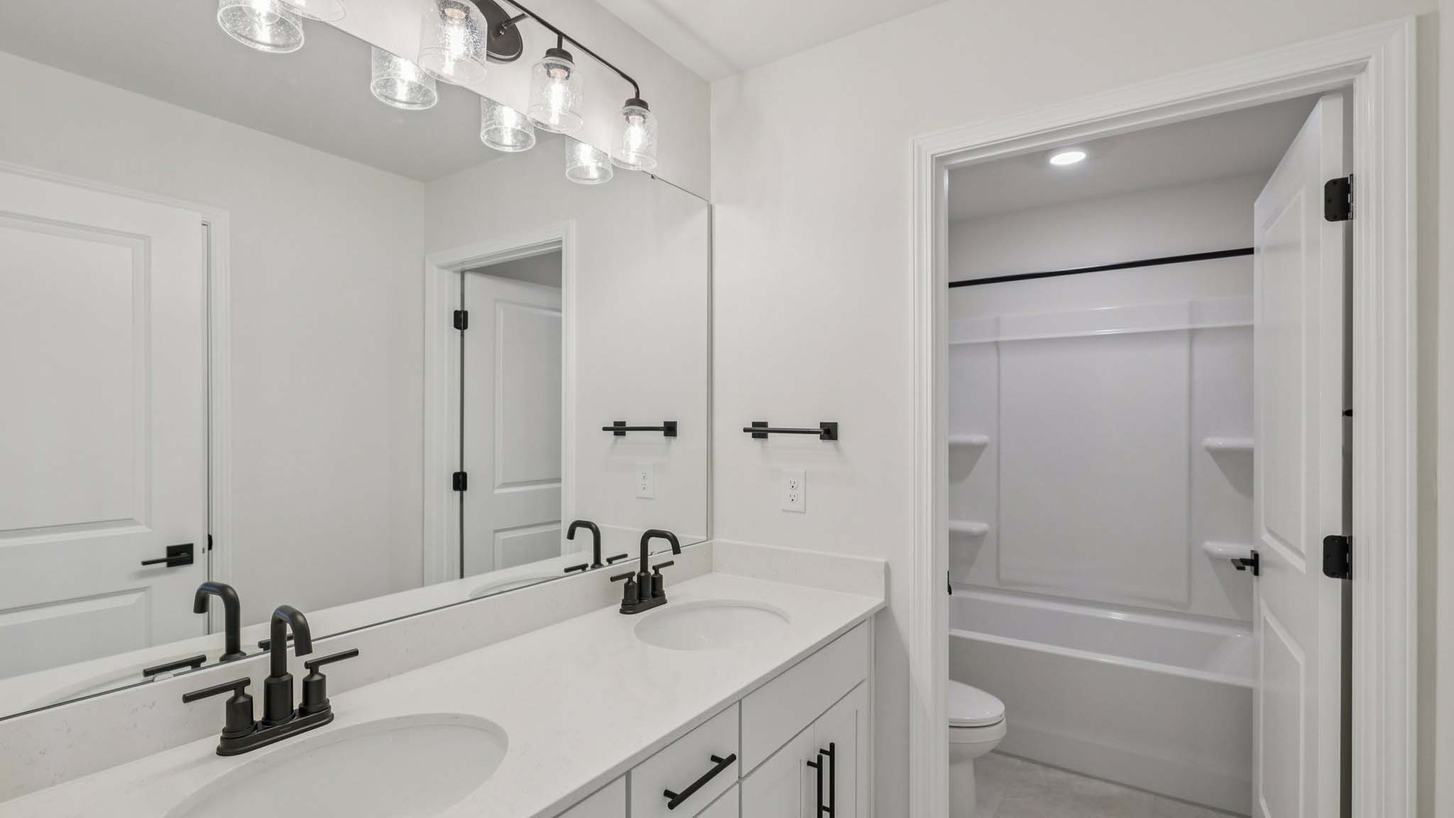 Bathroom with double sinks and tub shower combination