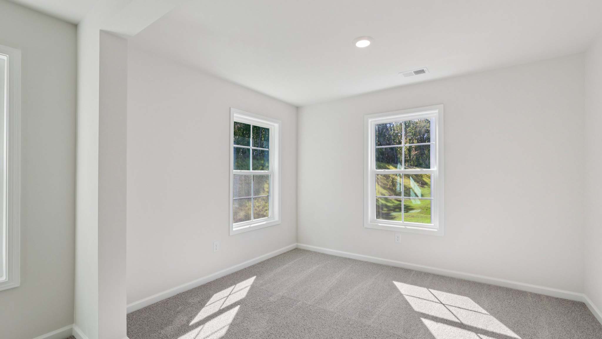 Primary carpeted bedroom with windows
