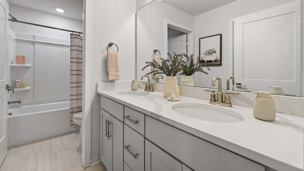 Bathroom with double sinks and tub shower combination