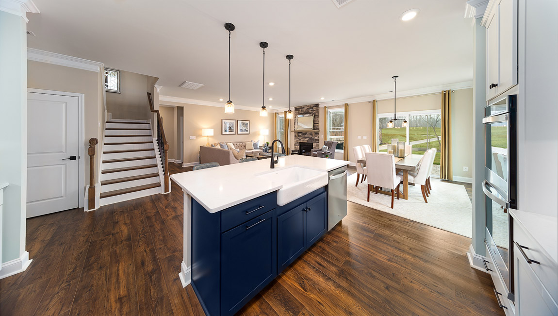 Kitchen and island with white countertops and white cabinets with stainless steel appliances