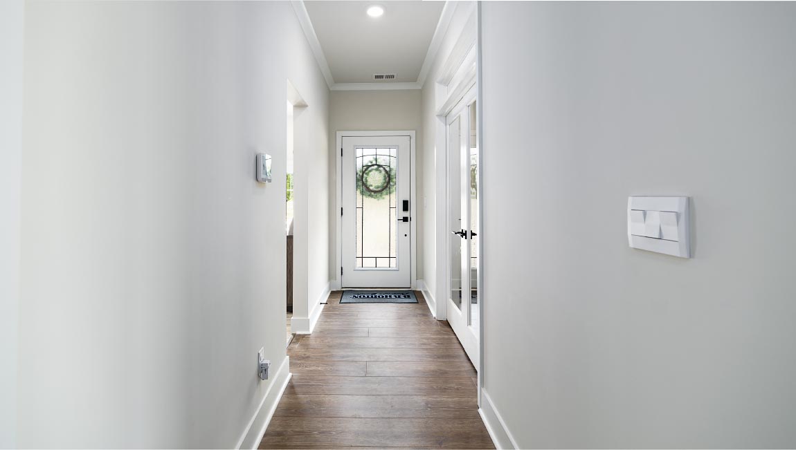 Welcoming foyer with wood floors, view of front door, and edge of dining room