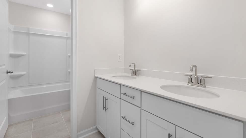 Bathroom with double sinks and tub shower combination