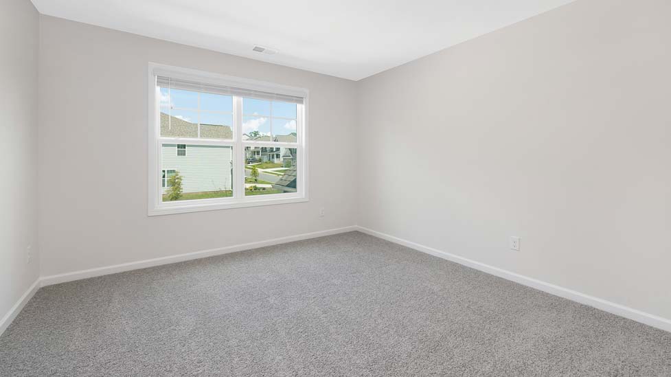 Carpeted bedroom with large window