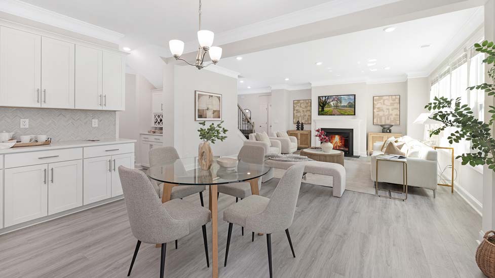 Kitchen and island with white cabinets, white rest of kitchen has brown cabinets