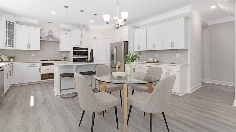 Kitchen and island with white cabinets, white rest of kitchen has brown cabinets