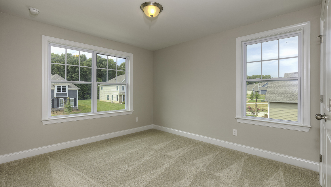 Carpeted bedroom with two large windows