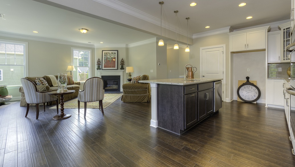 Kitchen and island with wood floors, white cabinets, and stainless steel appliances