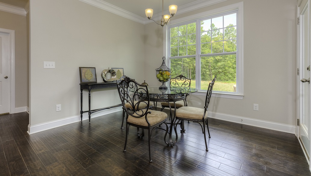 Breakfast area beside kitchen with wood floors, large window and back door