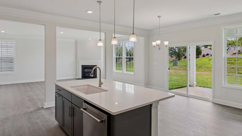 Kitchen and island with wood floors, white cabinets, and stainless steel appliances