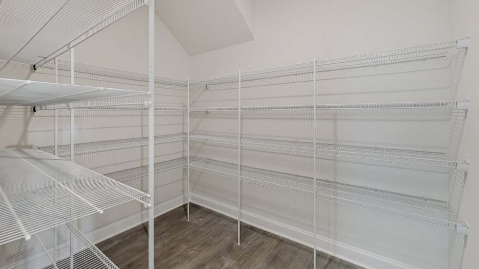 Kitchen and island with wood floors, white cabinets, and stainless steel appliances