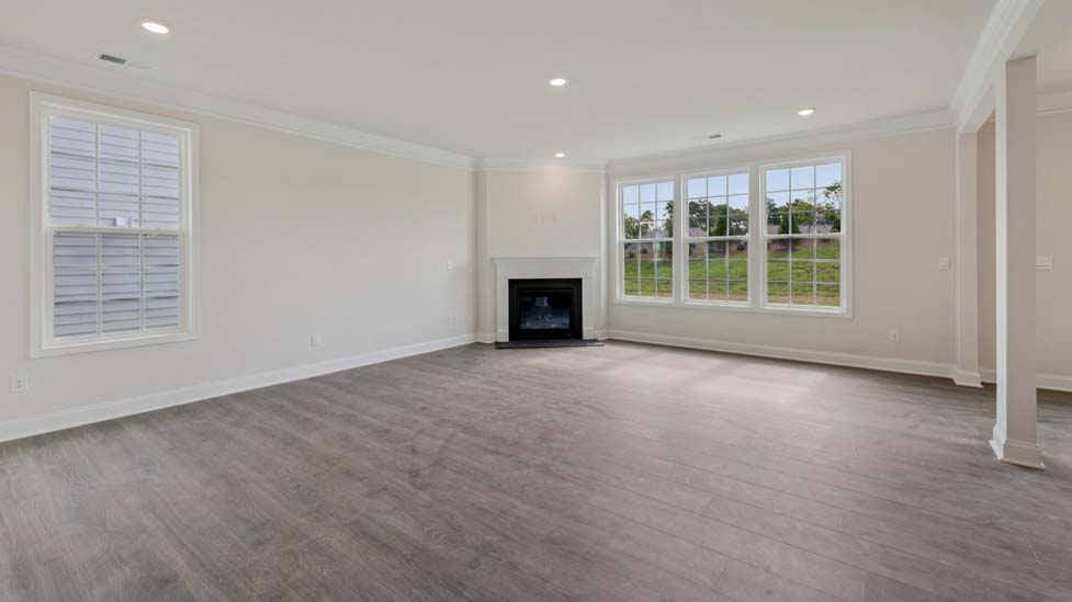 Family room with wood floors, fireplace and many large windows