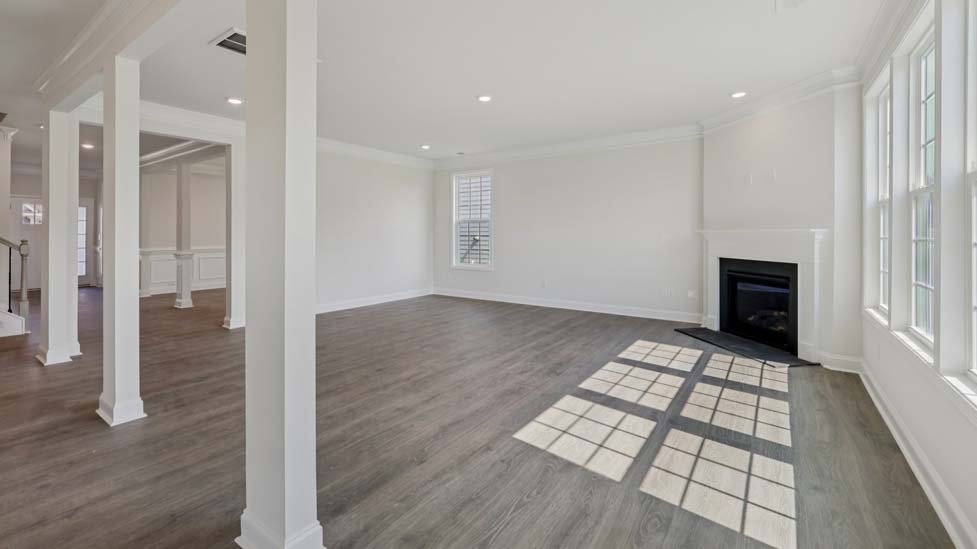 Family room with wood floors, fireplace and many large windows