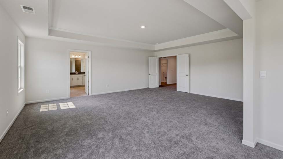 Primary bedroom with carpet, and large windows
