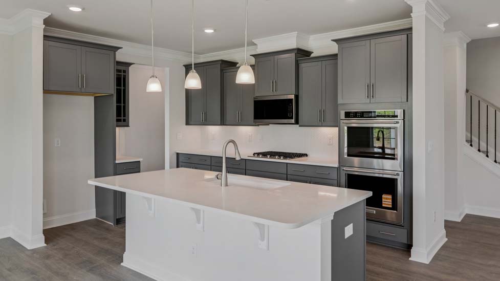 Kitchen and island with wood floors, white cabinets, and stainless steel appliances