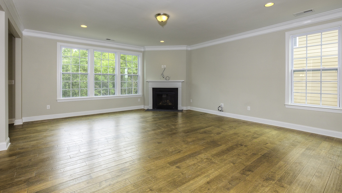 Family room with wood floors, fireplace and many large windows
