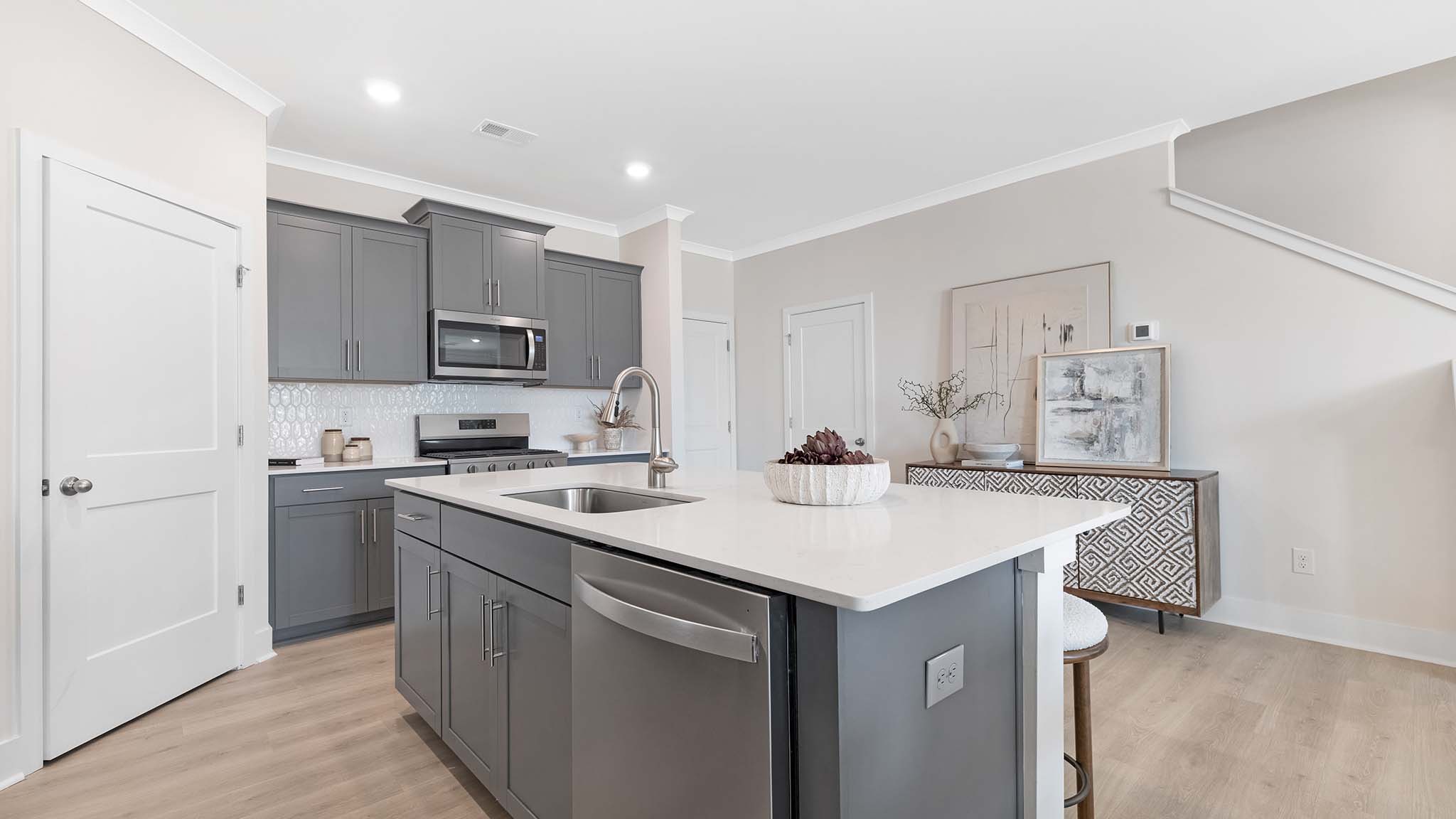 Kitchen and island with white cabinets and stainless steel appliances