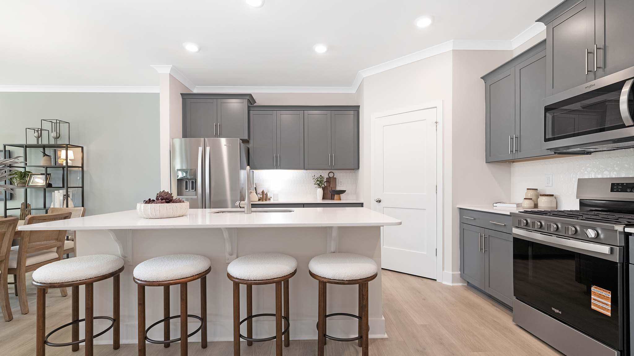Kitchen and island with white cabinets and stainless steel appliances