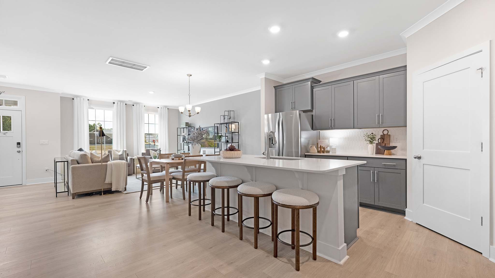 Kitchen and island with white cabinets and stainless steel appliances