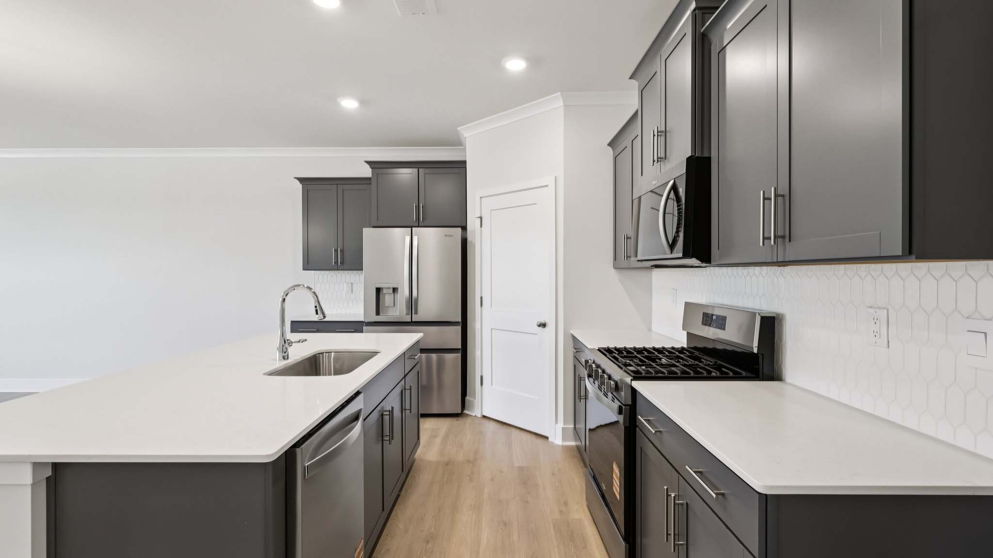 Kitchen and island with white cabinets and stainless steel appliances