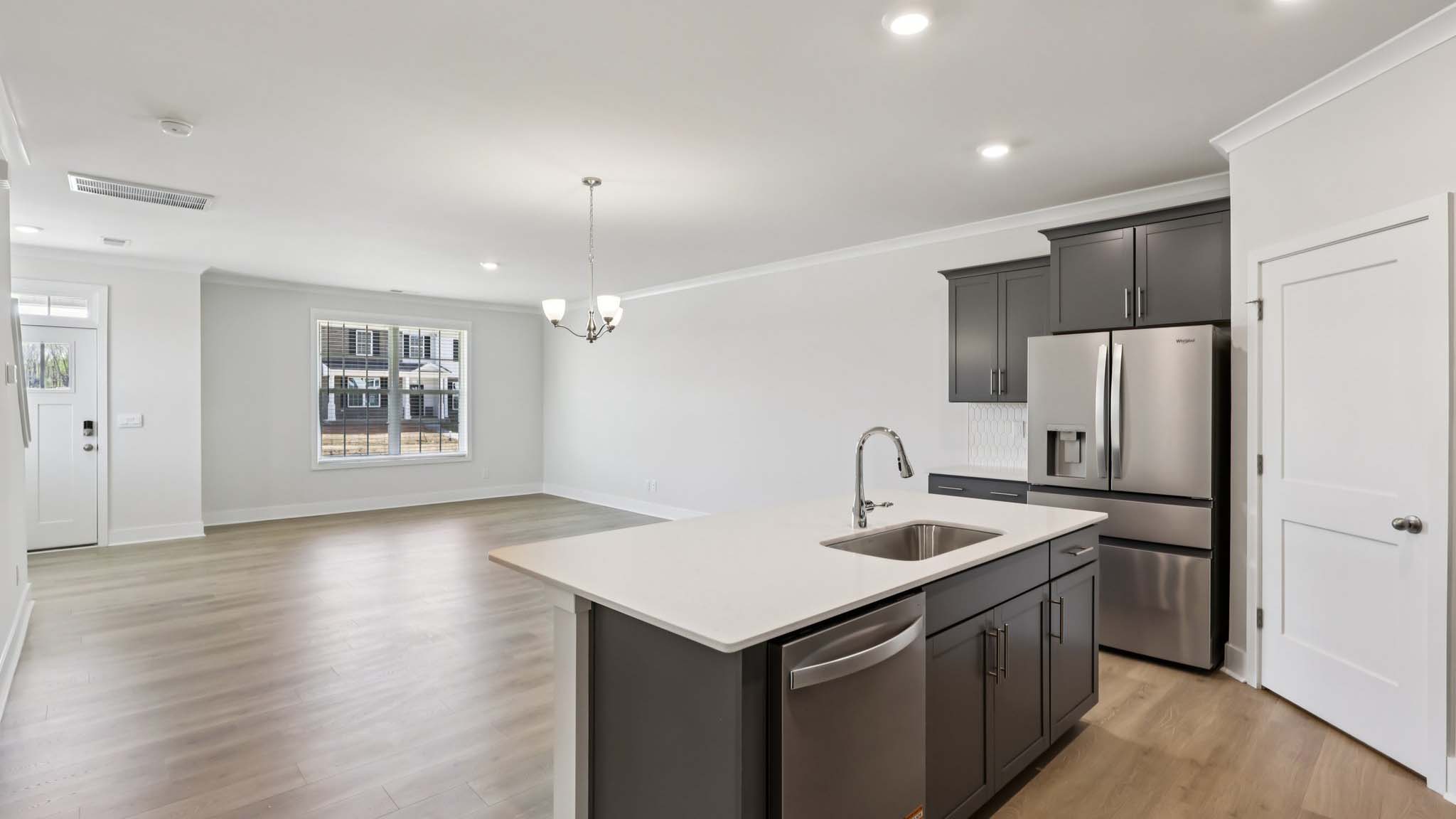 Kitchen and island with white cabinets and stainless steel appliances