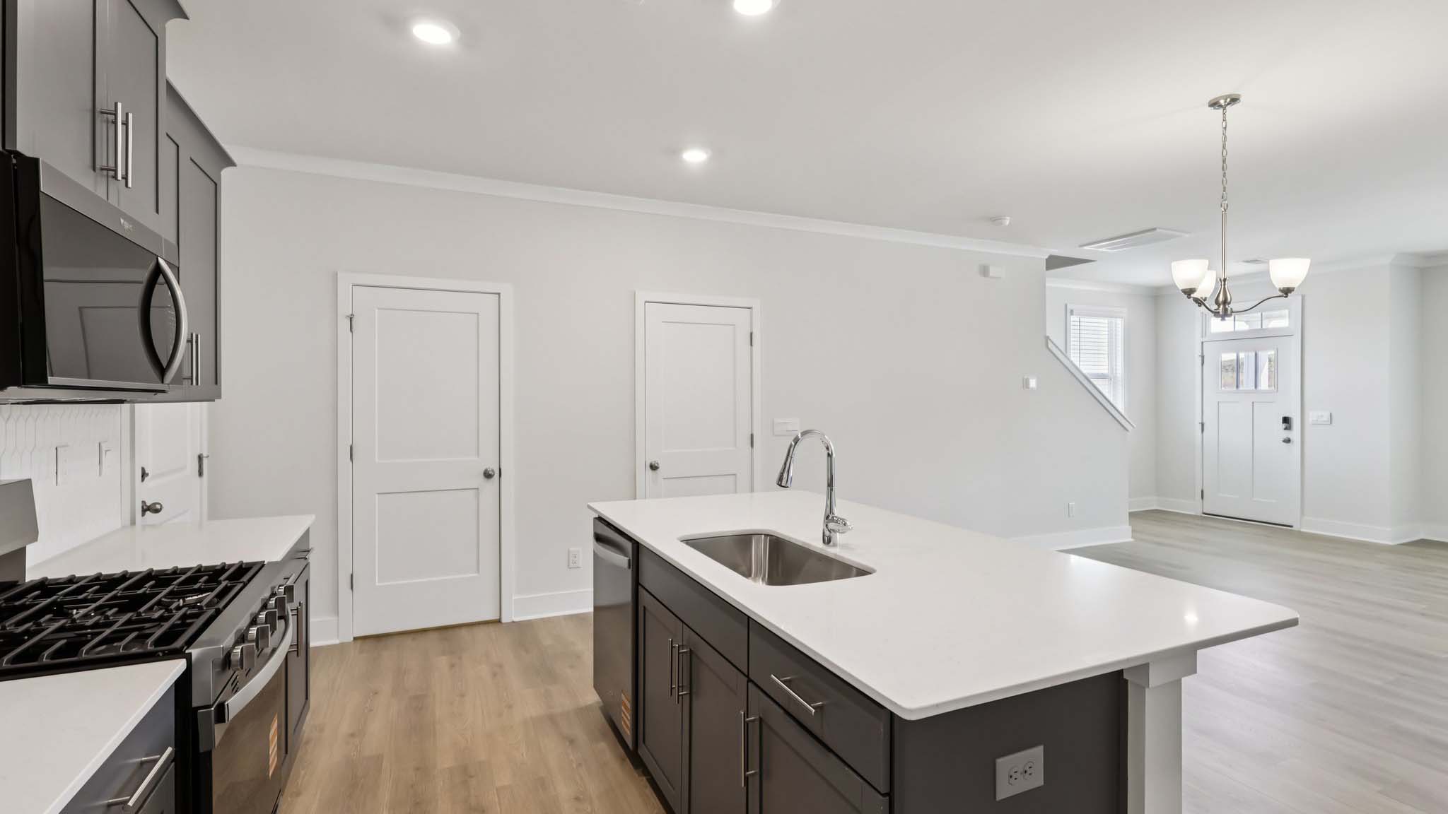 Kitchen and island with white cabinets and stainless steel appliances