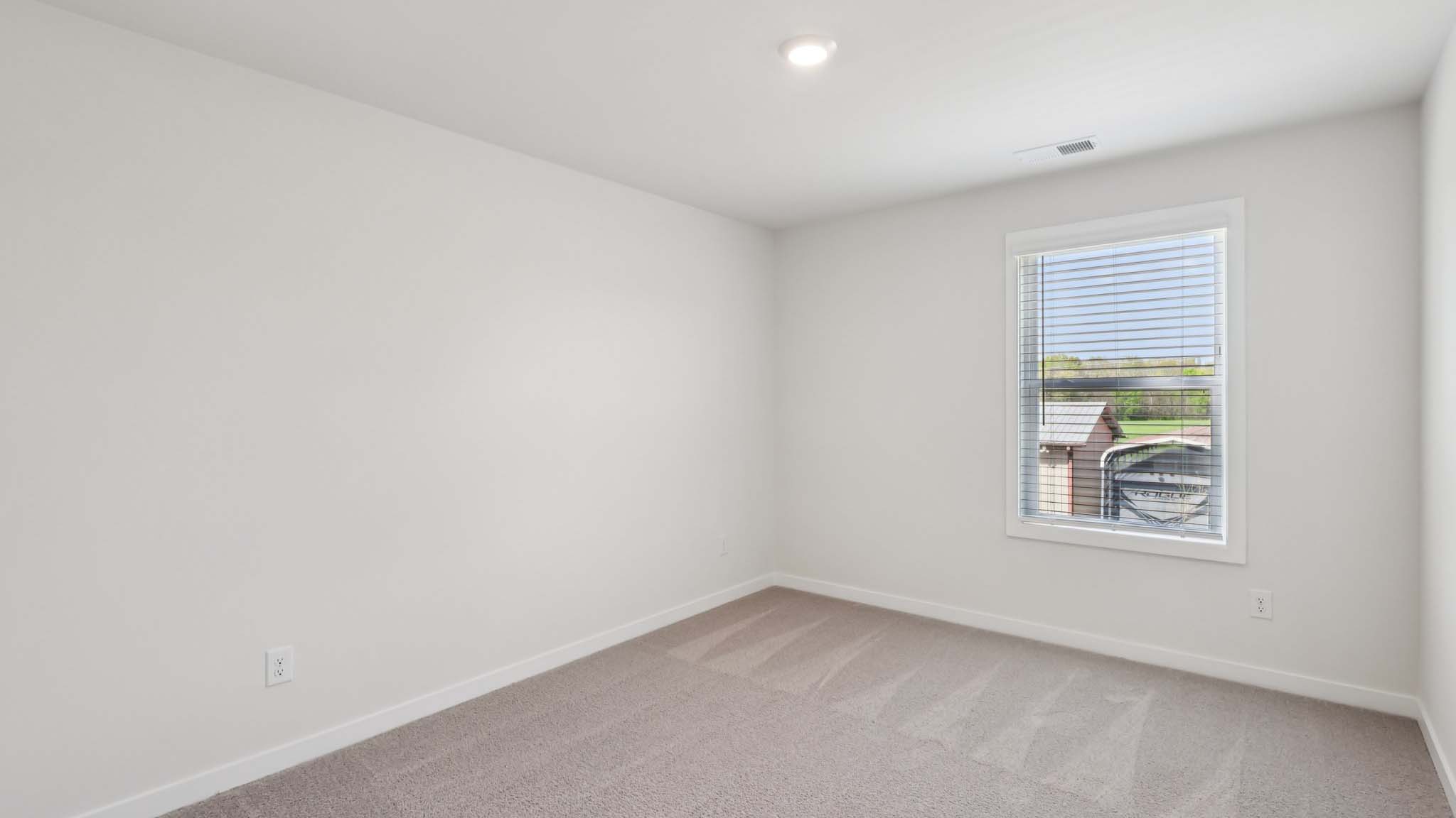 Carpeted bedroom with large window