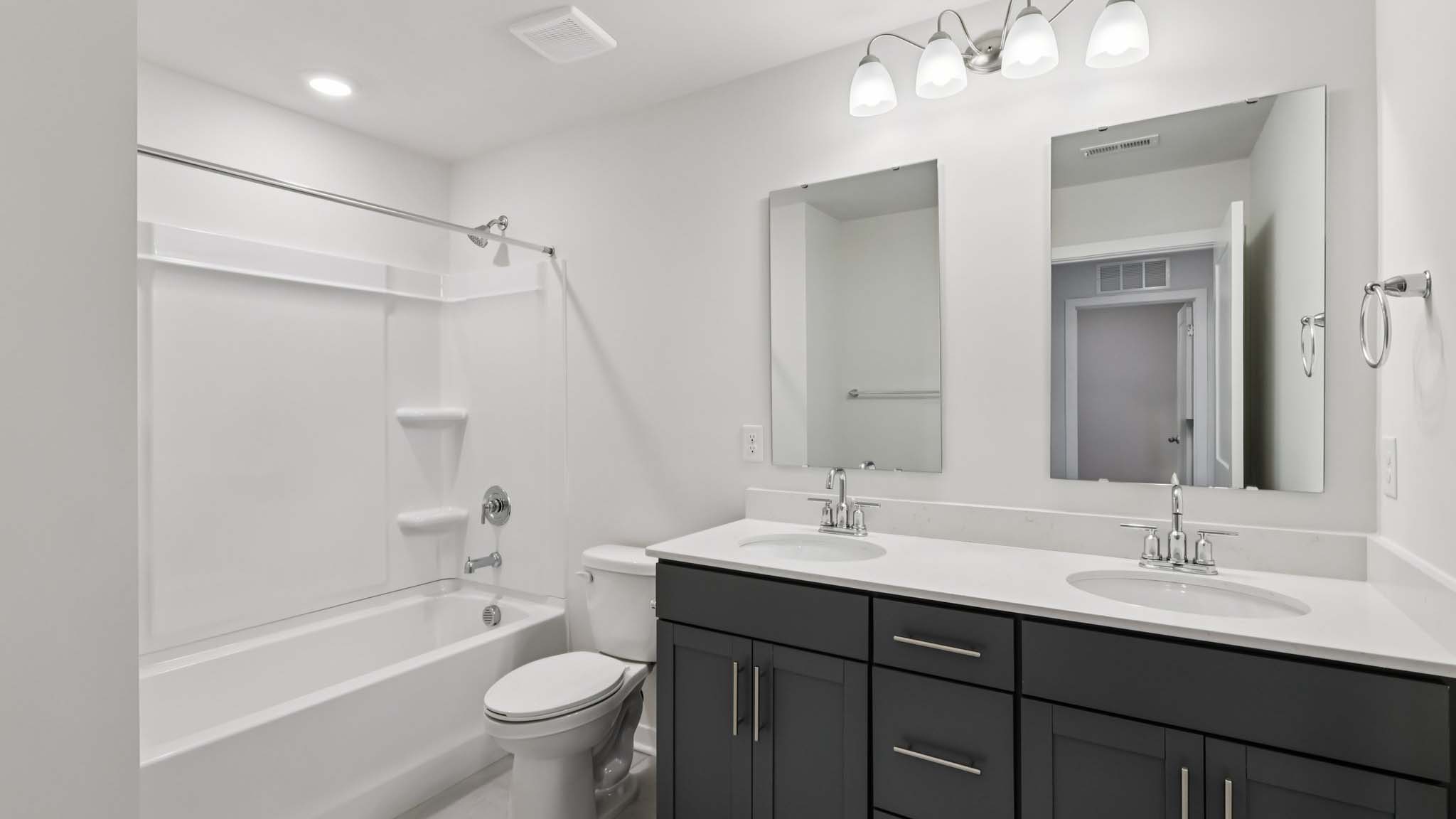 Bathroom with double sink vanity and bathtub shower combination