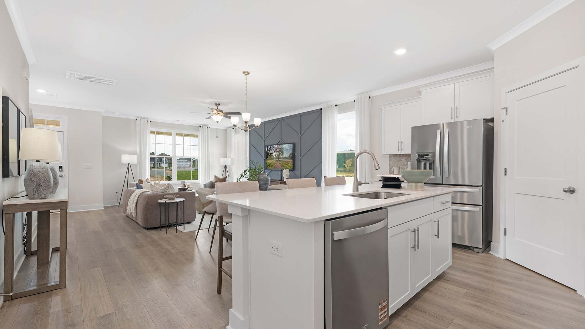 Kitchen and island with white cabinets and stainless steel appliances