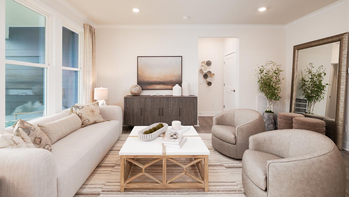 Living room area with large windows beside kitchen