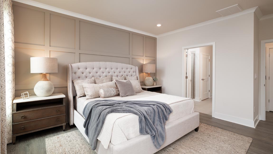 Primary bedroom with carpet and two small windows