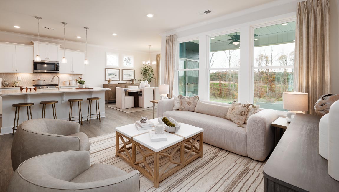 Living room area with large windows beside kitchen