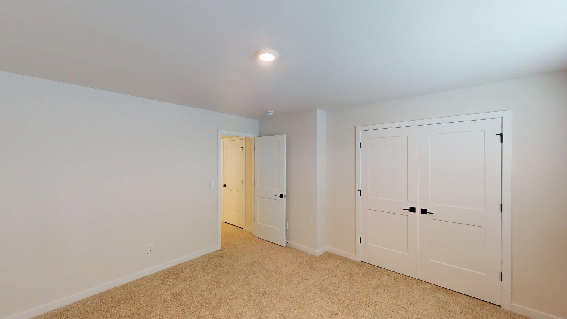 Large carpeted bedroom with windows