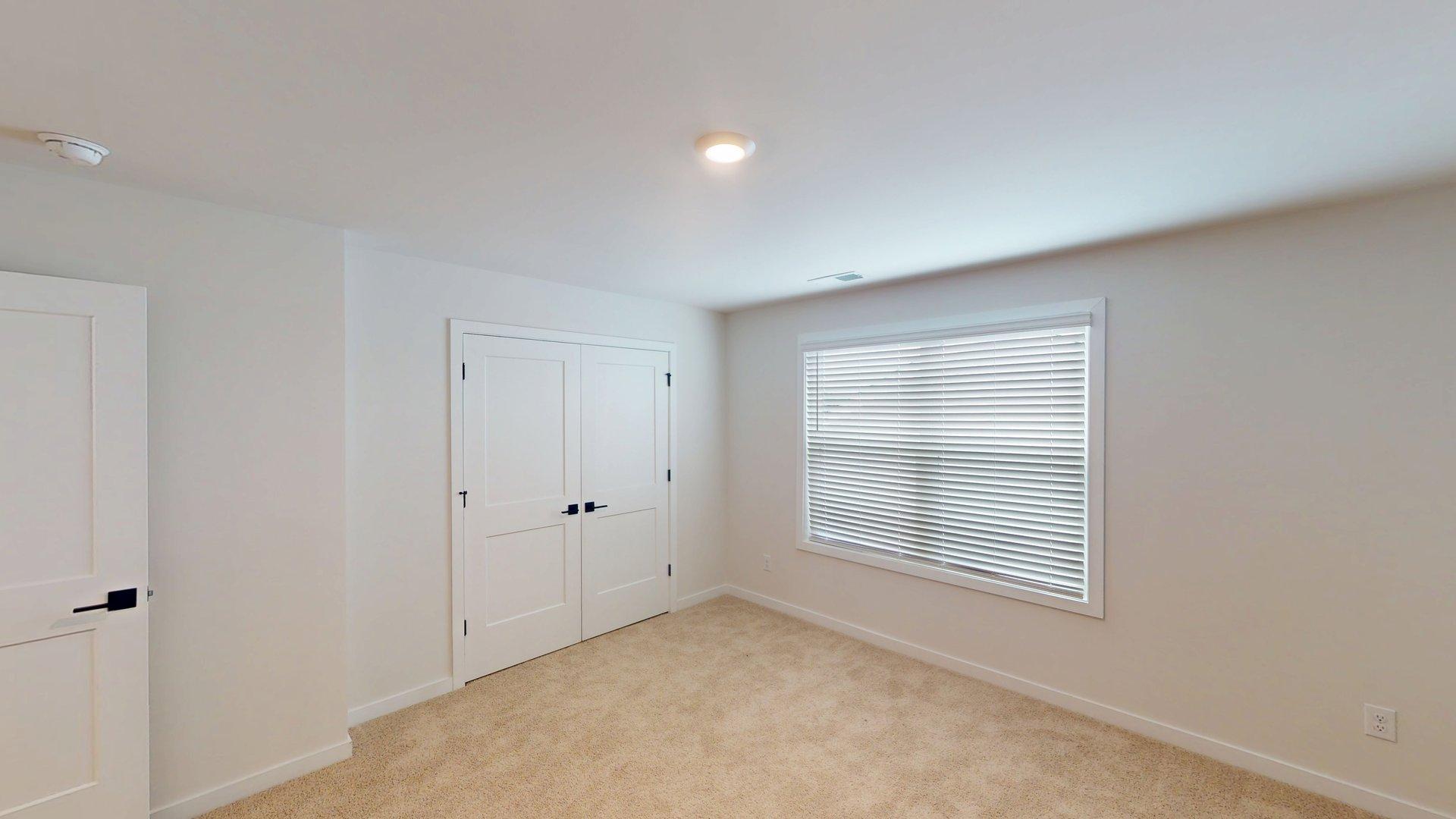 Large carpeted bedroom with windows
