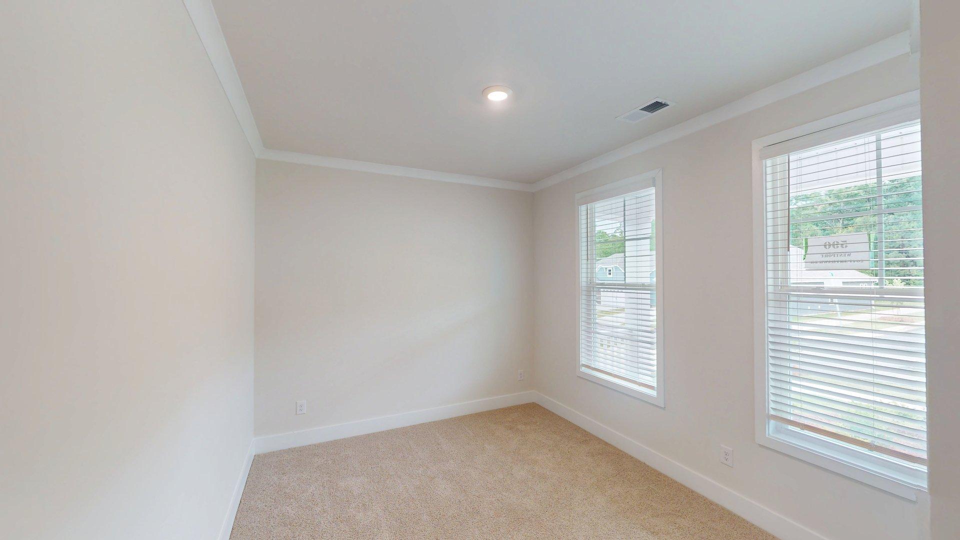 carpeted bedroom with large windows