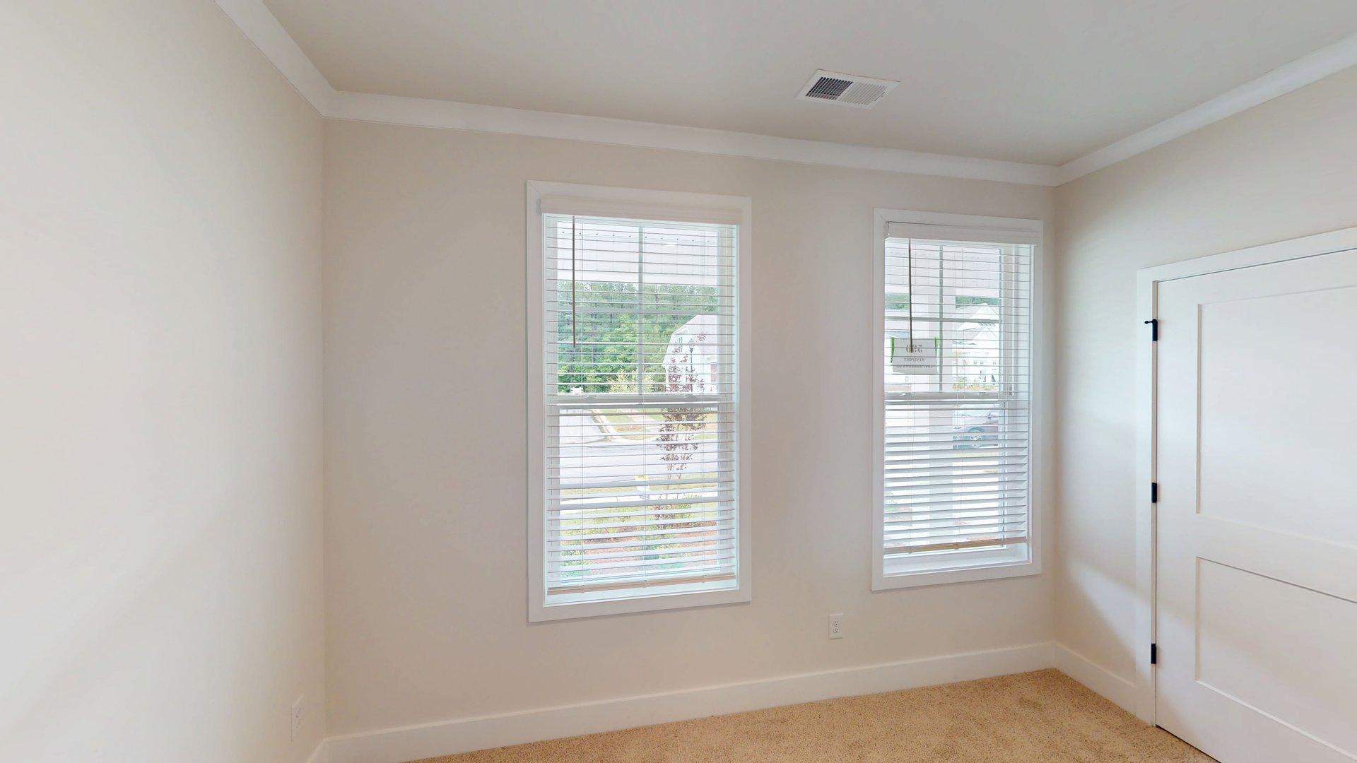 carpeted bedroom with large windows