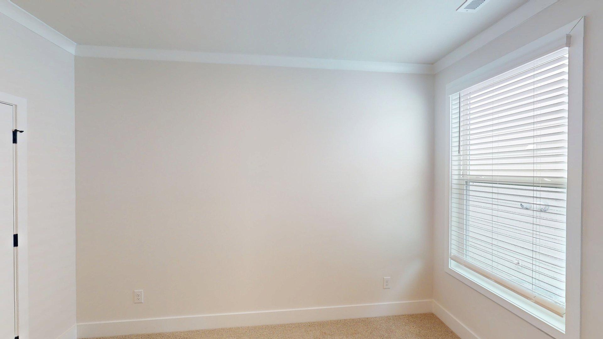 carpeted bedroom with large windows
