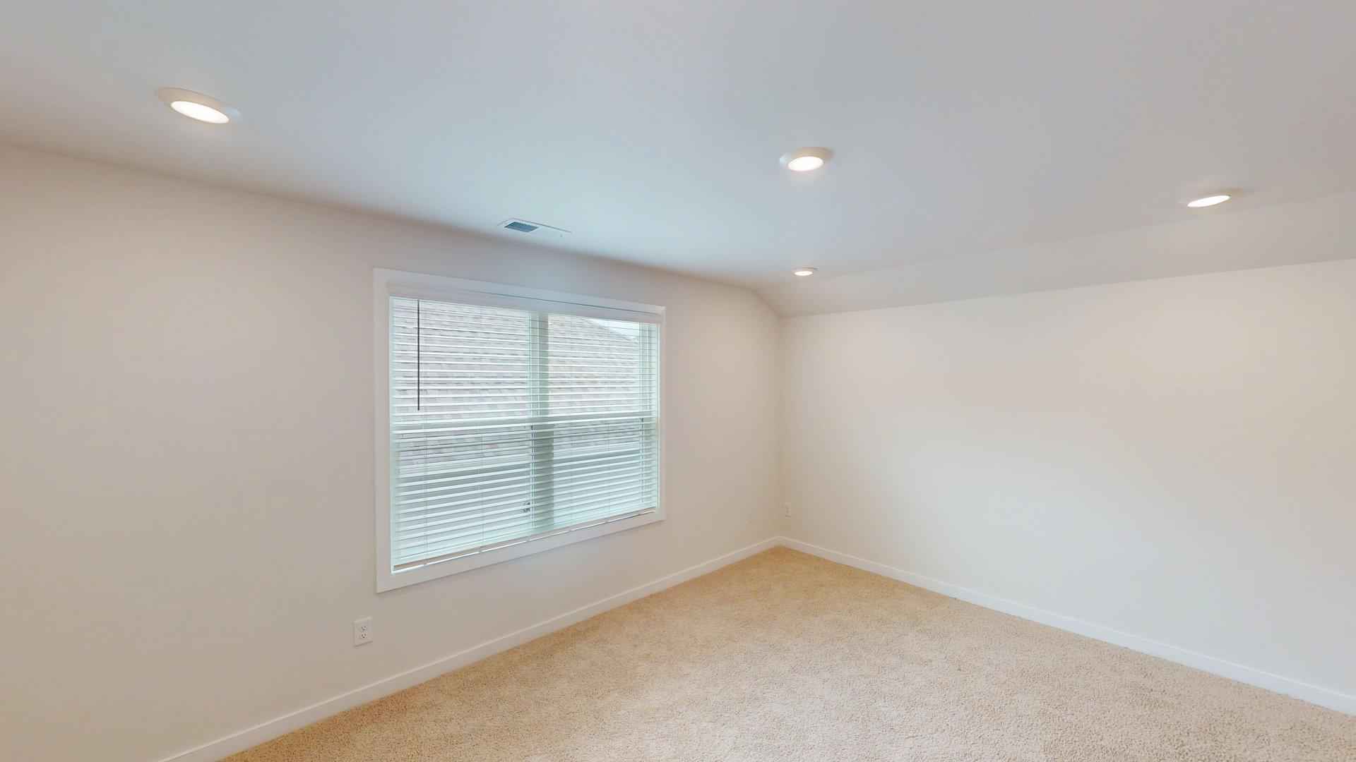 carpeted upstairs loft space with large windows