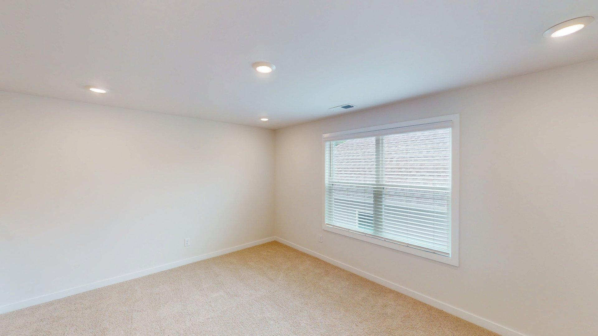 carpeted upstairs loft space with large windows
