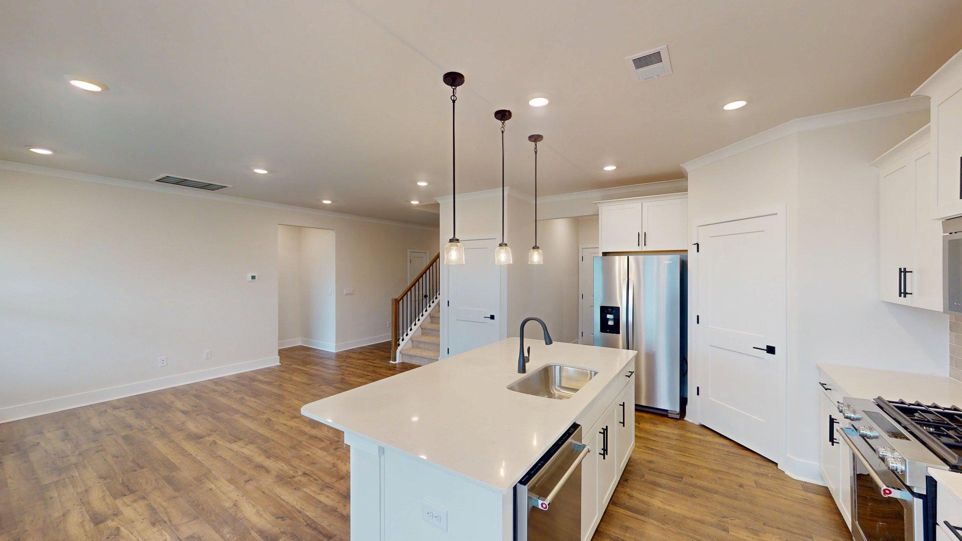 kitchen and island with large windows, white cabinets and stainless steel appliances