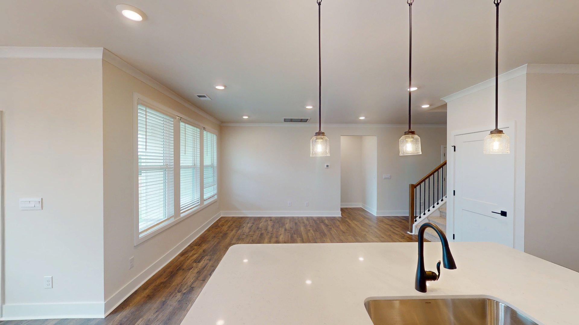 kitchen and island with large windows, white cabinets and stainless steel appliances