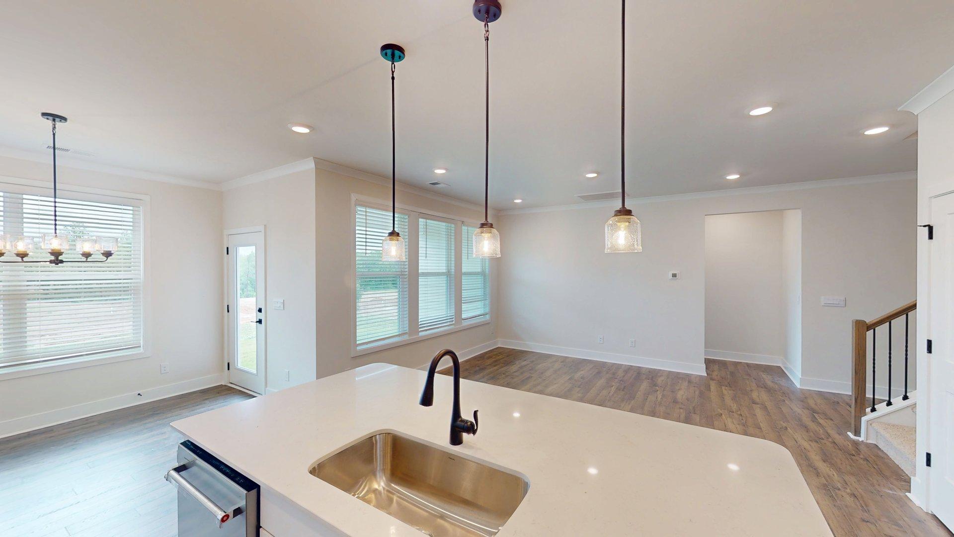 kitchen and island with large windows, white cabinets and stainless steel appliances