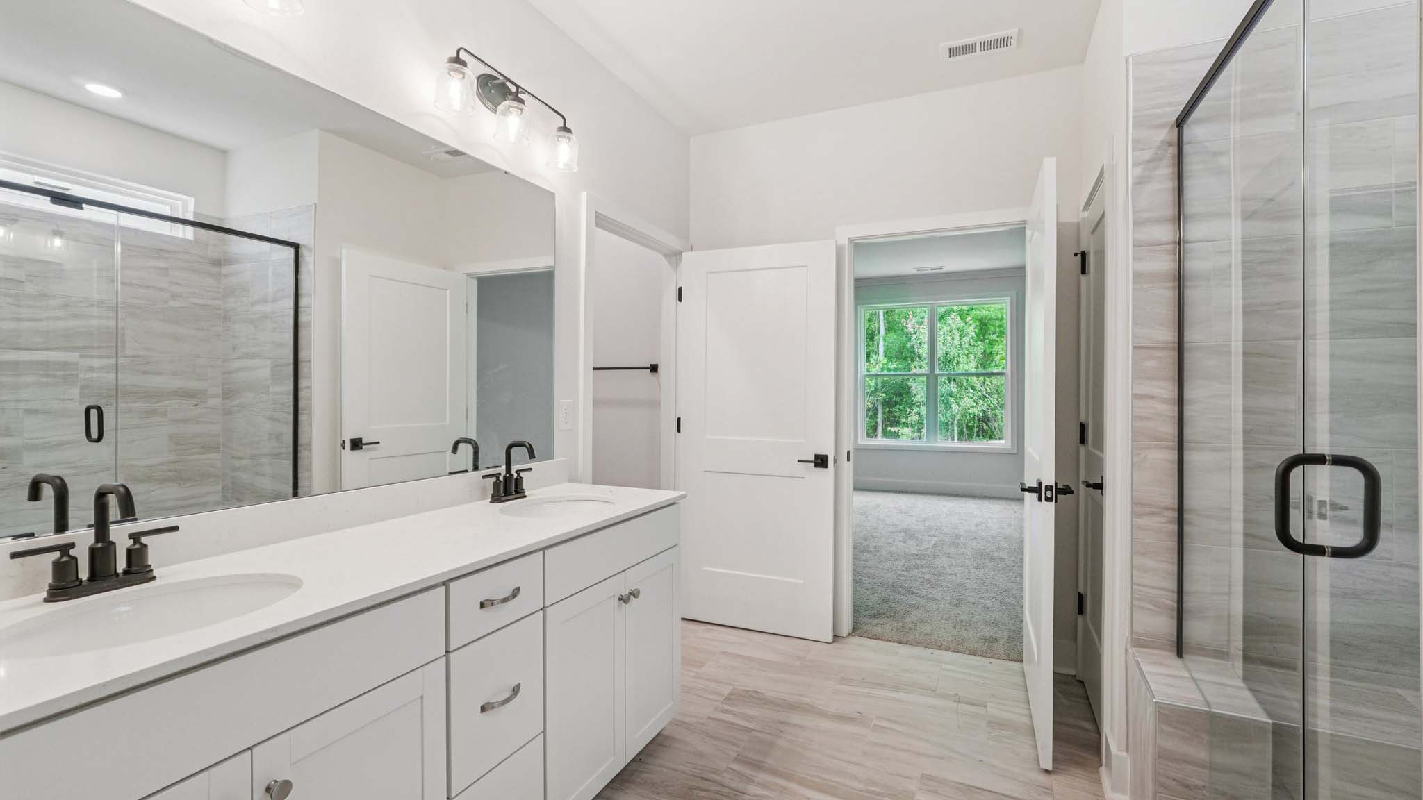Bathroom with double sinks and standing glass shower