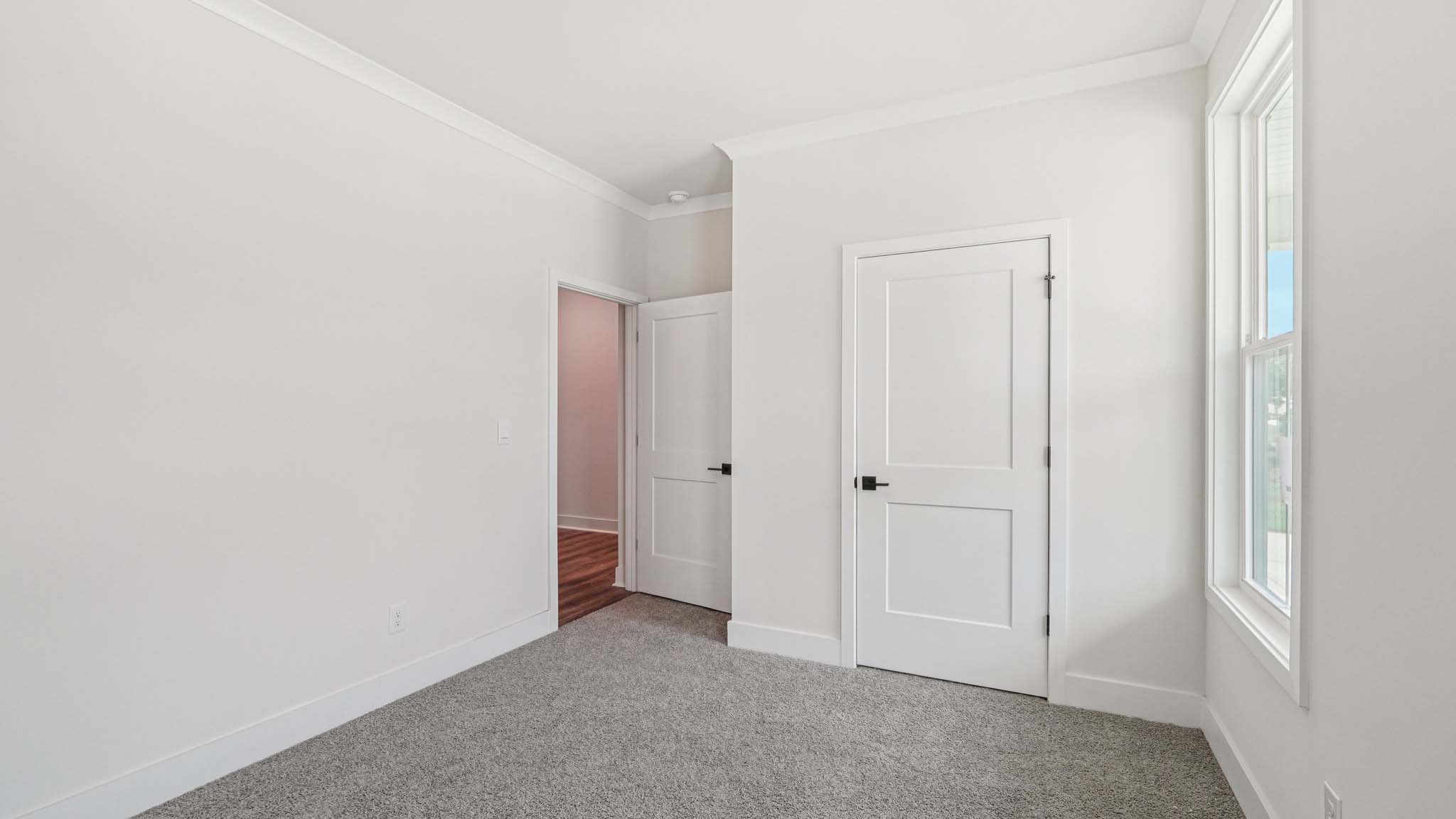 Carpeted bedroom with large windows